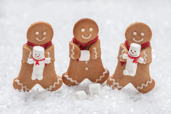 Смешные пряничные человечки с милым зефирным снеговиком — стоковое фото