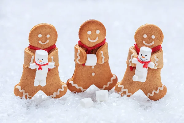 Смешные пряничные человечки с милым зефирным снеговиком — стоковое фото