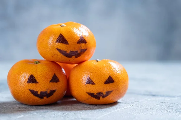 Caras divertidas en las naranjas de mandarín para Halloween . — Foto de Stock