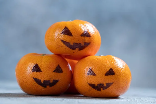 Caras divertidas en las naranjas de mandarín para Halloween . — Foto de Stock