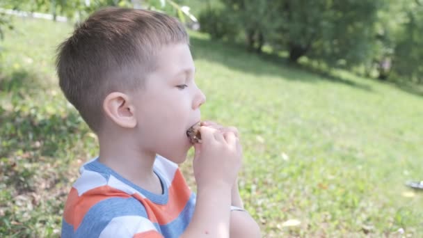 mignon gamin dehors manger un sandwich 