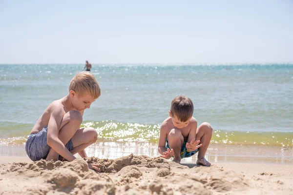 Счастливый ребенок играет с песком на пляже — стоковое фото
