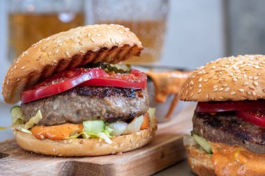 Sığır eti, domates ve salatalık ile iki lezzetli ev yapımı burger