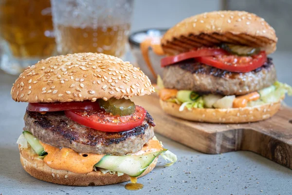 Dois deliciosos hambúrguer caseiro com carne bovina, tomate e pepino — Fotografia de Stock
