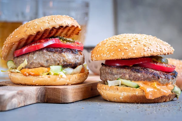 Two delicious homemade burger with beef, tomatoes and cucumber — Stock Photo, Image