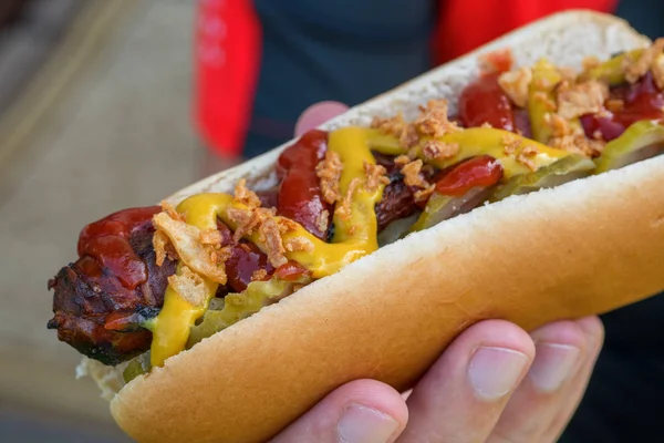 Hot Dog z boczku owinięte kiełbasa, ketchupu, musztardy, smażony cebulę i ogórki — Zdjęcie stockowe