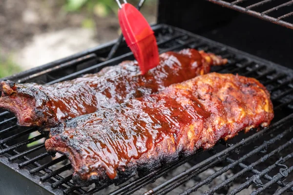 Costillas de cerdo cocinando en parrilla barbacoa — Foto de Stock