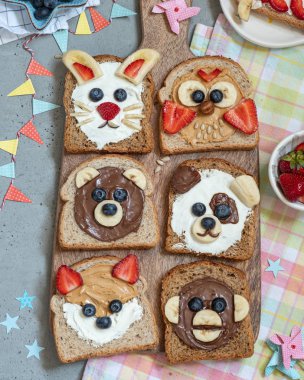 Hayvan yayılır, muz, çilek ve yaban mersini ile tost yüzleri