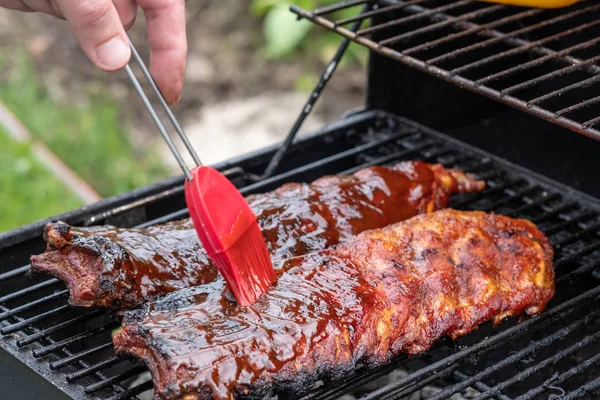 Costillas de cerdo cocinando en parrilla barbacoa — Foto de Stock