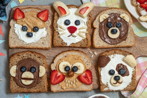 Animal faces toasts with spreads, banana, strawberry and blueberry — Stock Photo, Image