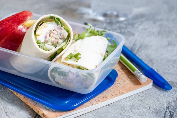 Tuna salad wraps in lunch box with apple — Stock Photo, Image