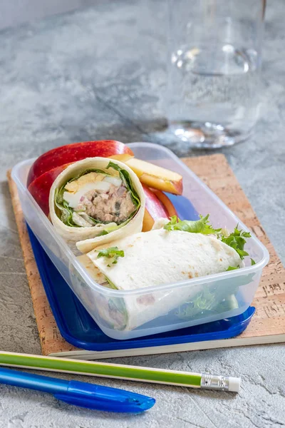 Tuna salad wraps in lunch box with apple — Stock Photo, Image