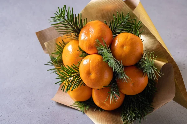 Handmade fruit bouquet of mandarin and Christmas tree branches