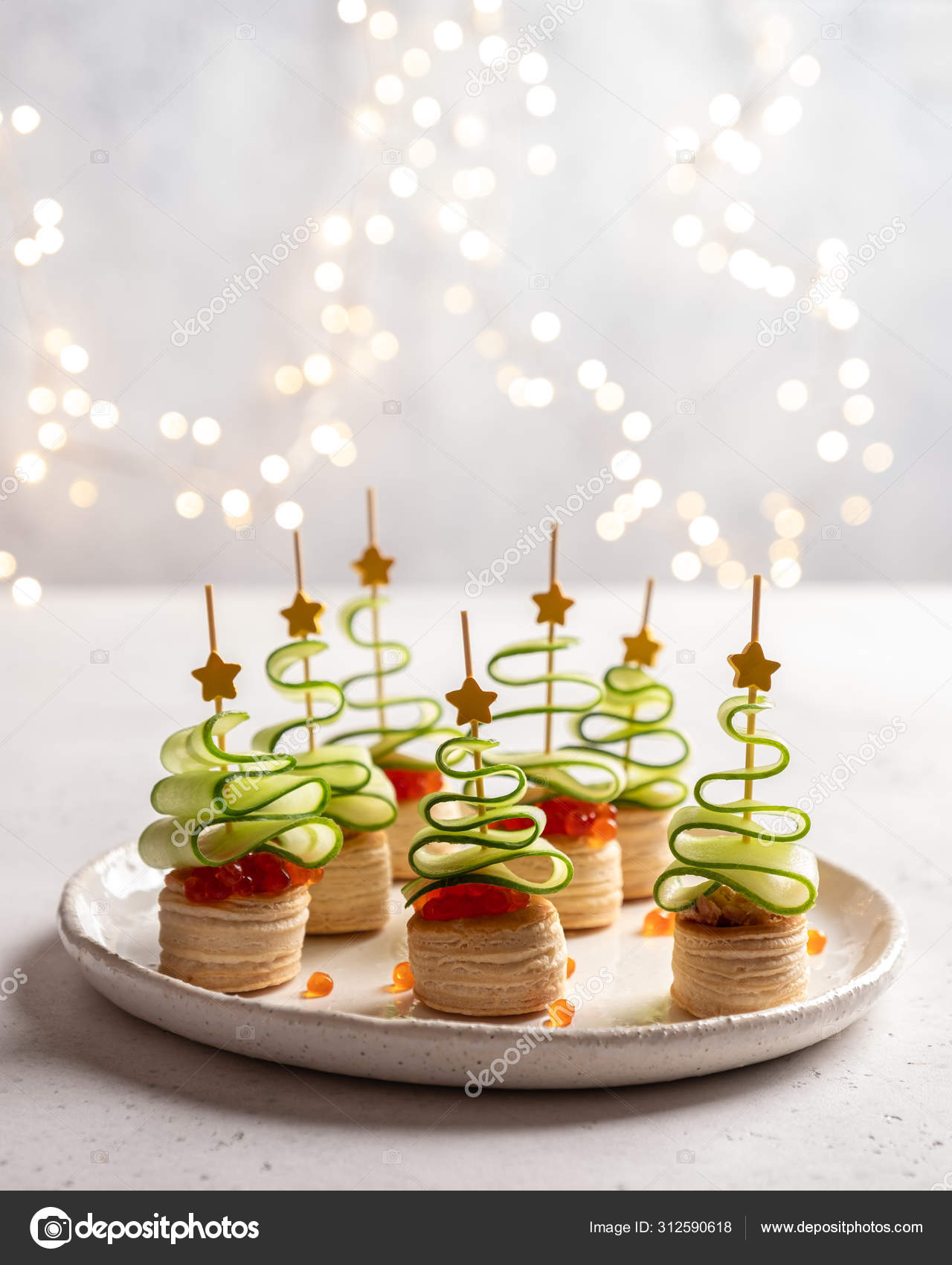 Christmas tree canape with cucumber slice, salmon pate and red - Main Image