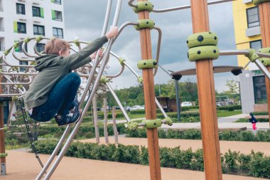 Sevimli çocuk oyun alanında oynuyor.