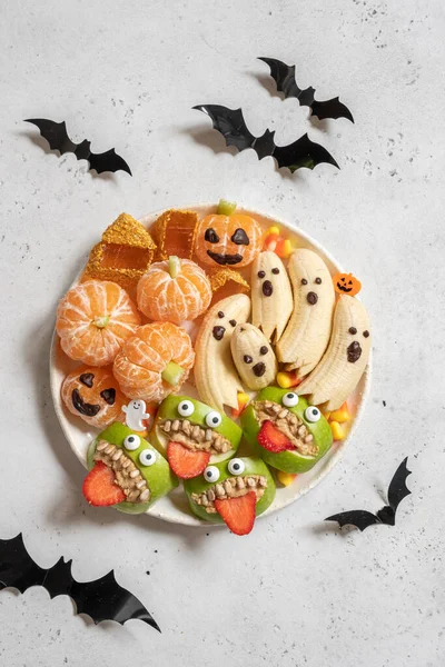 Golosinas saludables de Halloween. Fantasmas de plátano, calabazas de naranja clementina y monturas de monstruo de manzana — Foto de Stock