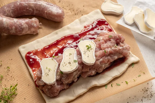 Rolos de salsicha de peru de porco cru com queijo brie e molho de cranberry em massa folhada — Fotografia de Stock