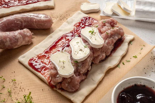 Rollos de salchicha de cerdo crudo con queso brie y salsa de arándanos en hojaldre —  Fotos de Stock