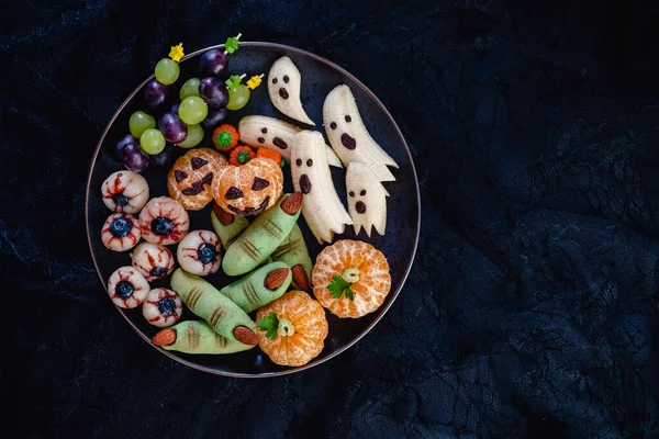 Здоровые фруктовые Хэллоуинские угощения. Банановые призраки, Клементина Оранжевые Тыквы и Глаза Личи — стоковое фото