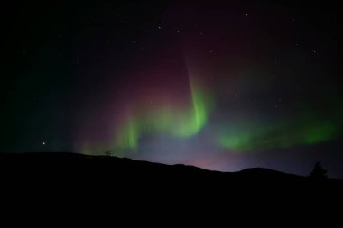 Kuzey ışıkları, Kuzey Norveç 'te kutup dairesinin ötesinde göksel bir manzara.