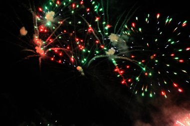 Gece gökyüzünde güzel havai fişekler. Bir buket kırmızı ve yeşil ışıklar. Noel ve yeni yıl kutlama