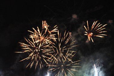 Gece gökyüzünde güzel havai fişekler. Bir buket sarı ve beyaz ışıklar. Noel ve yeni yıl kutlama