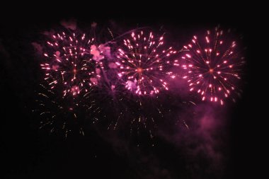 Havai fişekler. Havai fişek. Noel ve yeni yıl tatil sırasında gece gökyüzünde pembe parlak ışıklar flaş.