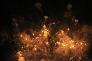  Havai fişekler. Selam. Yeni yıl ve Noel tatilleri sırasında gece gökyüzünde turuncu parlak ışıklar gökyüzü arka plan fantastik çelenk