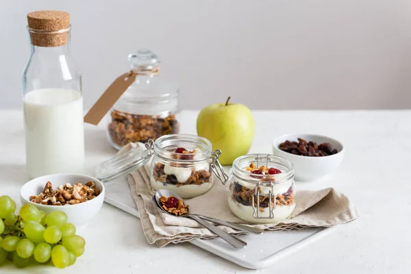 Healthy, vegeterian fiber food. Fruits, almond milk, honey granola in jars with flax seeds, cranberries, coconut, yogurt and cherry. Breakfast time. Dieting concept for banner. Copy space. Side view