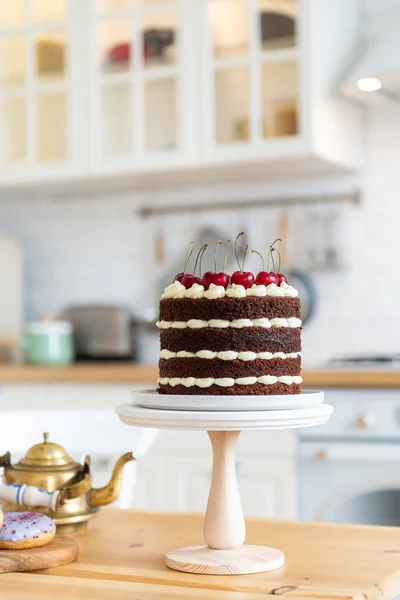 Naked chocolate cake with cherry. Black forest cake, Schwarzwalder Kirschtorte, Schwarzwald pie on the kitchen table. Home made birthday cake. Bakery concept. Copy space
