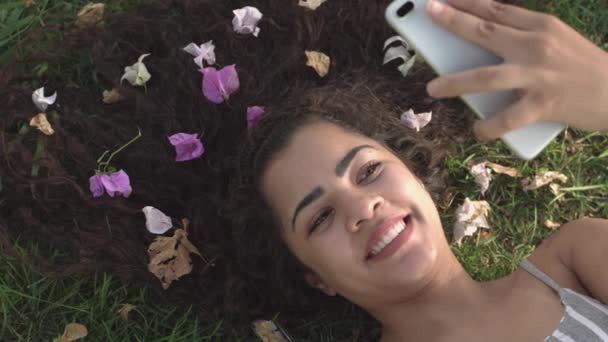 公園で彼女の携帯電話で Selfie を取って花髪スタイルを持つ女の子 — ストック動画