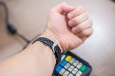 İletişim daha az ödeme. Akıllı bilezik ile ödeme. Ödeme sistemi giyilebilir bilezik aygıtları kavramı.