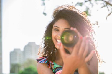 Bir kamera len dışında tutan siyah kadın