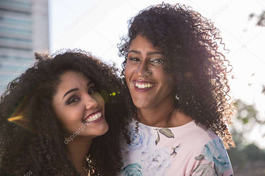 Two young afro girls having fun together, joy, positive, love, friendship, sisters. Happy meeting of two friends hugging. Lesbian concept.