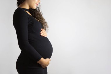 Yakın çekim stüdyo çekimi hamile kadının karnı çok dokunaklı. Beyaz arka plan üzerinde izole