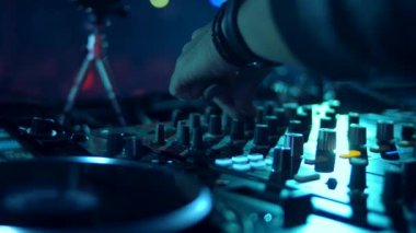 DJ parti kulübünde parça karışımları. Ön plan ve Dj kulaklık eller hareket halinde. Rave.