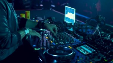 DJ parti kulübünde parça karışımları. Ön plan ve Dj kulaklık eller hareket halinde. Rave.