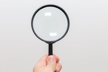 Beyaz arka planda büyüteçle el ele tutuşmak