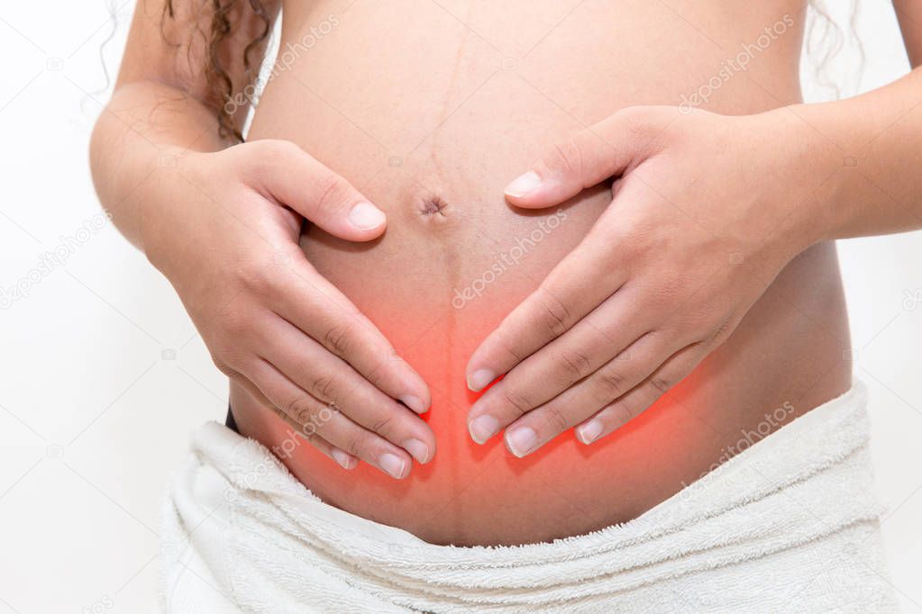 Pregnant woman with stomach ache holds her tummy in pain. Abdominal pain during pregnancy.