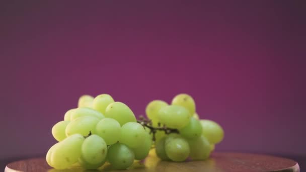 一串葡萄旋转360度的视频 紫色背景 提到酒 — 图库视频影像