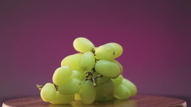 一串葡萄旋转360度的视频 紫色背景 提到酒 — 图库视频影像