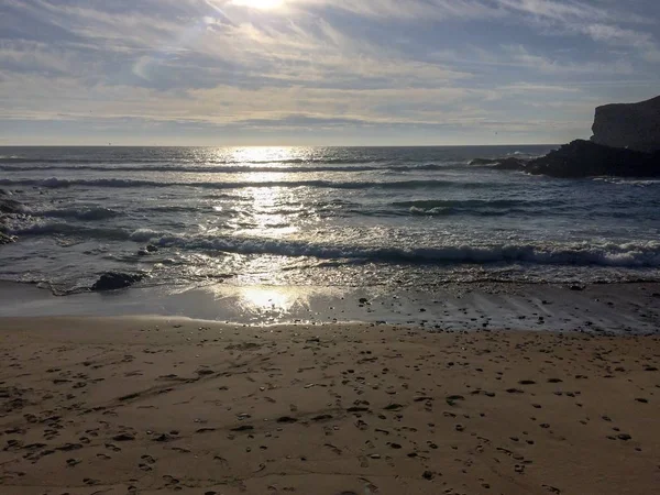 su üzerinde güneş parlama, deniz üzerinde gün batımı, kum ayak izleri, ıslak kum, sörf, deniz kayalar