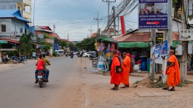 Kamboçya, Siem Reap 08/12/2018 turuncu giysiler içinde birkaç Budist keşiş yol kenarında durmak, birkaç scooter yol boyunca binmek