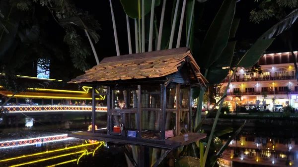 bird cage by the river, night time