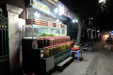Siem Reap, Kamboçya, 13 Aralık 2018 büfebaharat ve konserve meyve satıyor. Baharat kavanozları ve konserve meyveleri olan bir raf. Sokak ticareti.
