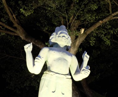 Dört elleri ve birkaç yüzü olan bir Hindu tanrıheykeli, gece aydınlatması, Asya kültürü