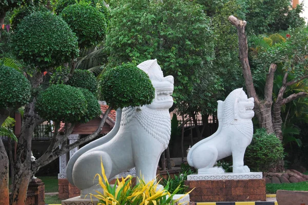 Two White Stone Sculptures Lions Beautifully Trimmed Ornamental Trees — Stock Photo, Image