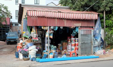 Siem Reap, Kamboçya, 17 Aralık 2018 endüstriyel malların küçük bir dükkan. Mağazanın yakınında küçük mavi bir araba..