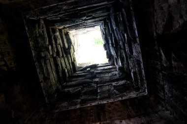 Derin kuyu, duvarları taşla kaplı. Alt görünüm. Tünelin sonundaki ışık. Yolun sonundaki ışık. Arka plan.