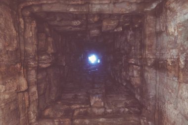 Derin kuyu, duvarları taşla kaplı. Alt görünüm. Tünelin sonundaki ışık. Yolun sonundaki ışık. Arka plan.